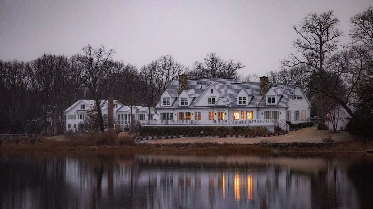 Charming white house by a lake in Connecticut, demonstrating serene surroundings
