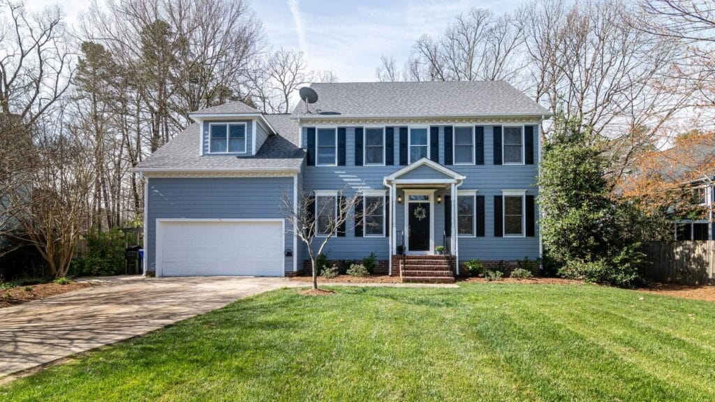Blue-gray suburban home with black shutters and an attached garage.