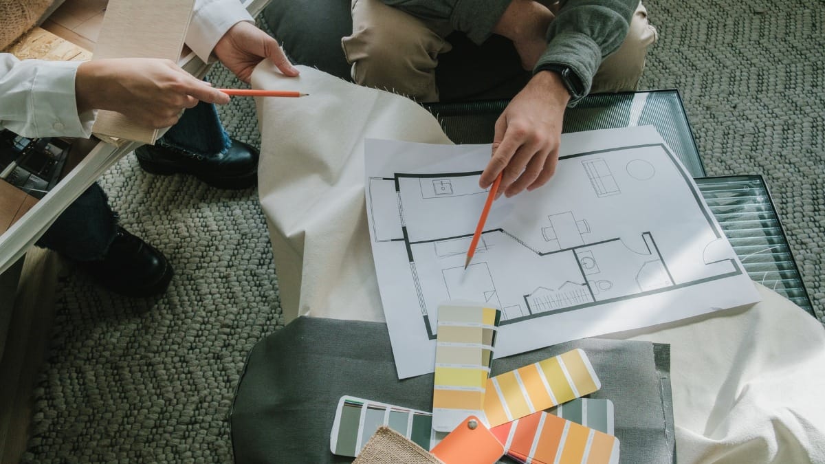 Designers reviewing a floor plan alongside paint swatches