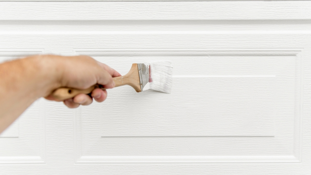 holding a wooden paintbrush